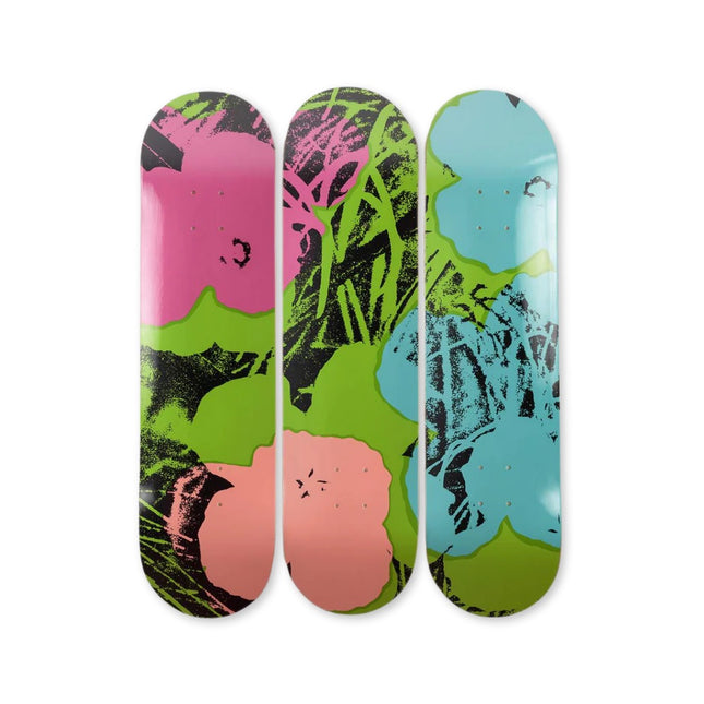 Set of three skateboards featuring "Flowers (Green/Pink)" by Andy Warhol with colorful floral pop art design.