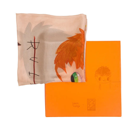Full view of "Rules" by Javier Calleja showing a folded textile with character motifs alongside its bright orange packaging.
