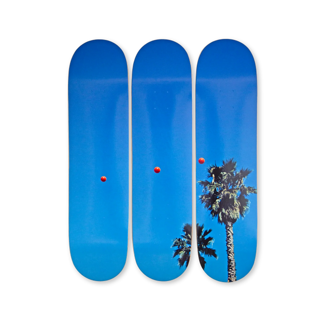 Complete view of "Throwing Three Balls in the Air to get a Straight Line (Best of Thirty-Six Attempts)" by John Baldessari on skateboard decks showing red balls and palm trees.