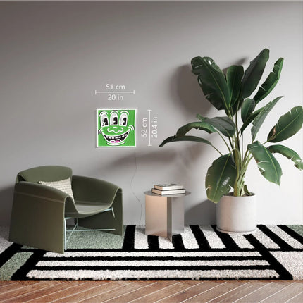 “Triple Eyes YP x Keith Haring” artwork displayed on a modern living room wall with plant and armchair nearby